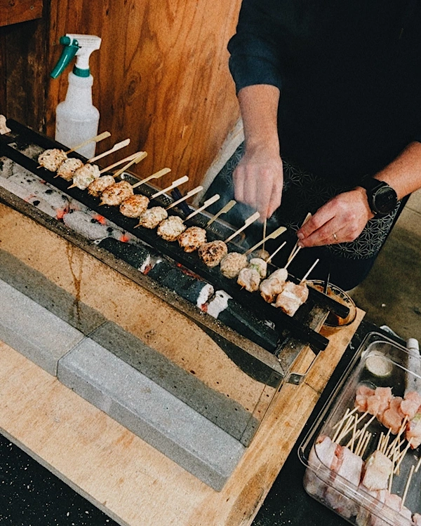 A row of chicken meatball skewers on a japanese style grill